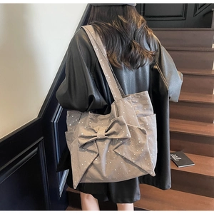 Detail of grey bow canvas tote bag featuring white star prints and spacious side pocket
