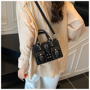 Detail of vintage black crossbody bag featuring matte leather and silver studded pockets
