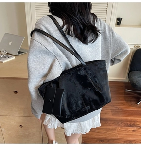 Détail du sac cabas en velours noir avec boucle latérale et petite pochette assortie
