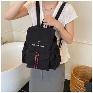 Detailed side view of black waterproof backpack with 'take it easy' text and side drawstring