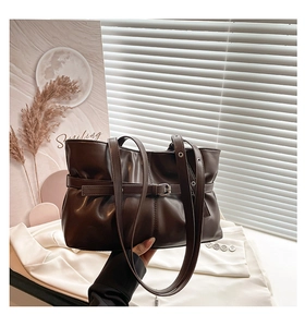 Détail d'un grand sac cabas marron foncé avec boucles décoratives et intérieur spacieux