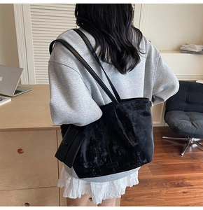 Détail du sac cabas noir texturé avec une pochette zippée assortie dans un espace de travail
