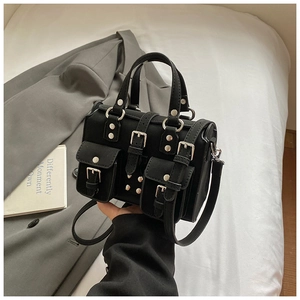 Detail of black multi-pocket crossbody bag with silver buckles and utility style