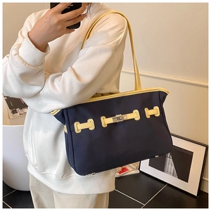Detailed view of two-tone canvas tote with leather trim and metal twist lock closure