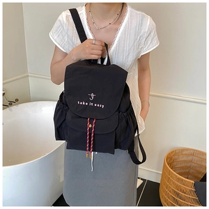 Détail du sac à dos en toile noire avec broderie et fermeture à cordon de serrage
