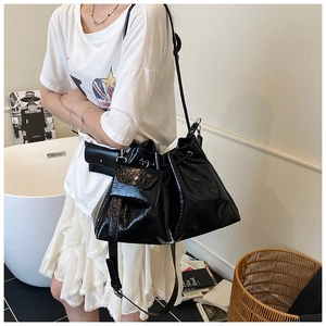 Détail du sac seau noir en cuir verni plissé avec cordon et mini pochette assortie