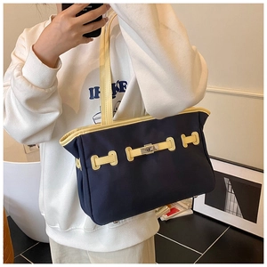 Mirror selfie showing a large blue canvas tote bag with beige leather trim and metal clasp