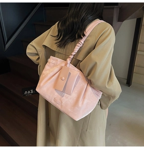 Détail du sac à bandoulière plissé rose avec sangle nouée et petit porte-cartes amovible