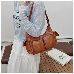 Detailed view of a brown glossy PU shoulder bag featuring multi-pocket utility design
