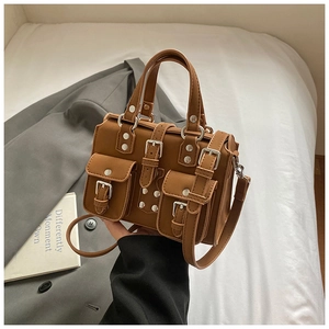 Detail view of a vintage brown multi-pocket handbag with silver buckles and dual handles