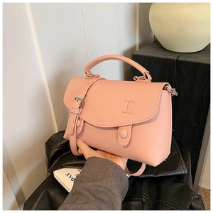 Dettaglio borsa rosa con finitura in pelle martellata e tracolla coordinata moda