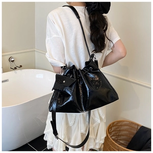 Détail du sac seau noir plissé brillant avec une petite pochette assortie amovible