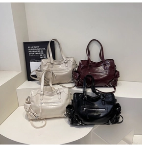 Group display of chic studded tote bags in beige, burgundy, and black on a white pedestal