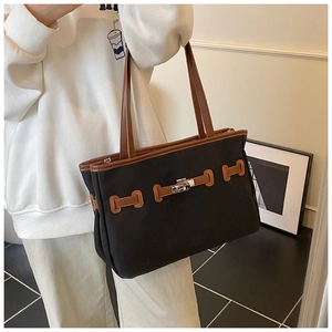 Detail of the vintage contrast bucket bag featuring a metal twist lock and leather trim