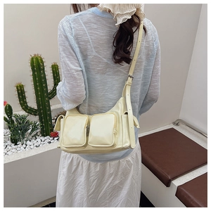 Detail view of a cream yellow multi-pocket leather shoulder bag with Y2K style vibes