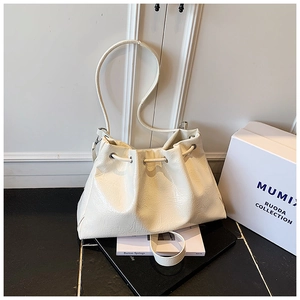 Détails de la texture plissée et du cordon de serrage du sac seau moderne en similicuir