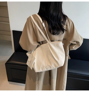 Grand sac fourre-tout beige avec pochette assortie, porté à l'épaule dans un style chic
