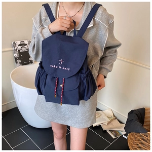 Detail of navy blue drawstring canvas backpack with pink take it easy logo and side pockets