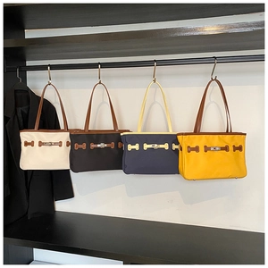 Collection of four minimalist canvas tote bags with leather handles and metal buckle details