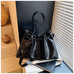 Vue détaillée du sac seau noir plissé avec cordon de serrage et cuir verni brillant