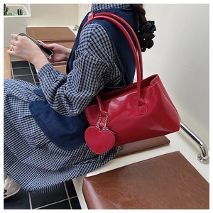 Borsa sottobraccio rossa lucida con ciondolo a cuore rimovibile e spalline sottili