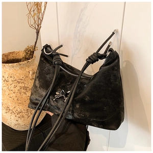 Detail of black Hobo tote bag with liquid metal silver bow and knotted shoulder strap