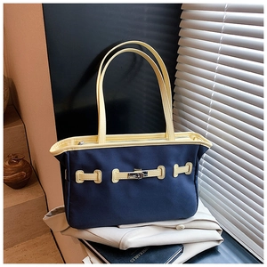Detail of color-block tote bag with yellow straps and silver metal buckle closure