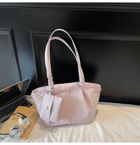 Ensemble cabas rose avec poignée torsadée sur un bureau blanc avec accessoires de style