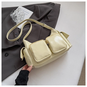 Detail view of cream PU leather crossbody bag with multiple pockets and adjustable strap