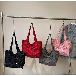 Side view of canvas tote bags with star print and bow detail in four colors