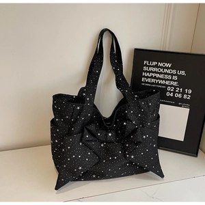 Detail of black canvas tote bag with white star pattern and large decorative bow