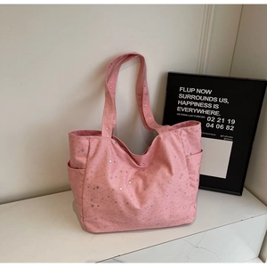 Detail of pink canvas tote bag with silver star prints and side storage pockets