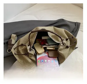 Detail showing the large storage capacity of the green plaid tote with various daily items