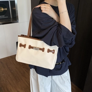 Contrast color leather bucket bag with top handle and vintage twist lock in a chic style