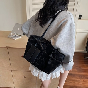 Grand sac cabas noir minimaliste avec bandoulière et pochette amovible porté par mannequin