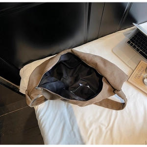 Top view of large canvas shoulder bag interior with durable zipper and laptop setup