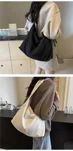 Détail de sacs fourre-tout plissés en noir et beige crème avec un drapé de tissu doux