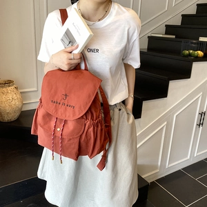 Minimalist brick red canvas backpack with drawstring and take it easy logo print