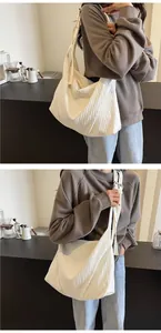 Gros plan sur la texture plissée et la toile souple de ce grand sac fourre-tout blanc