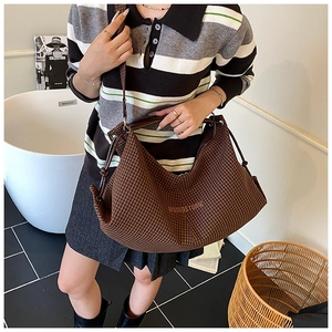 Detail of hobo shoulder bag with brown houndstooth pattern and elegant leather strap