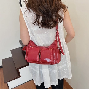 Vintage red glossy shoulder bag with multiple pockets and adjustable leather strap