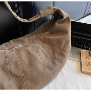 Detail shot of khaki canvas croissant bag showing thick fabric texture and silver zipper