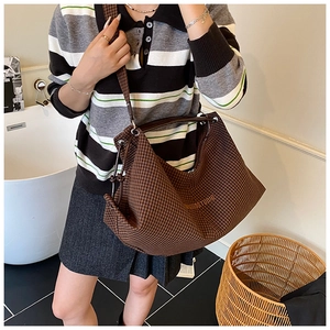 Macro view of brown checkered hobo bag with zip closure and adjustable shoulder strap