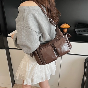 Retro dark brown glossy shoulder bag with multiple pockets shown in lifestyle setting