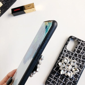 Détail de la coque noire pailletée avec une grande fleur en cristal et découpes latérales