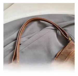 Vue détaillée du sac en daim marron foncé avec des finitions métalliques dorées chic
