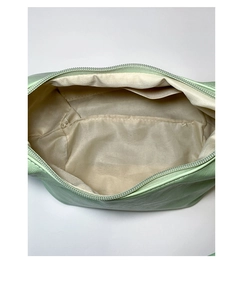 Detail view of the mint green crescent bag's interior with inner pocket and zipper
