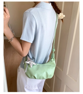 Detail of mint green crescent bag with soft PU leather pleats and silver star charm