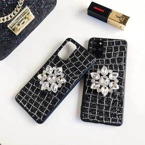 Détails de la coque noire pailletée avec motif à carreaux argentés et fleur en cristal