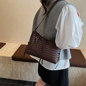 Minimalist dark coffee woven leather shoulder bag with fine strap in elegant scenery
